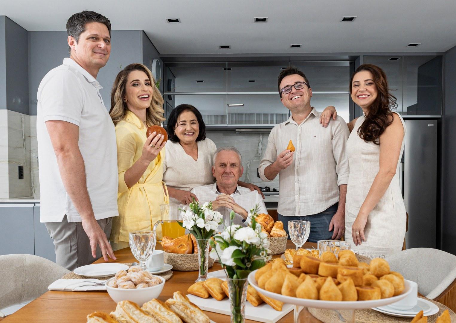 Família fundadora da Du'Cava reunida na cozinha, com a mesa de salgados da marca